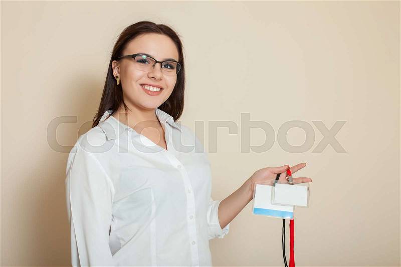 Female office worker shows empty badges, stock photo