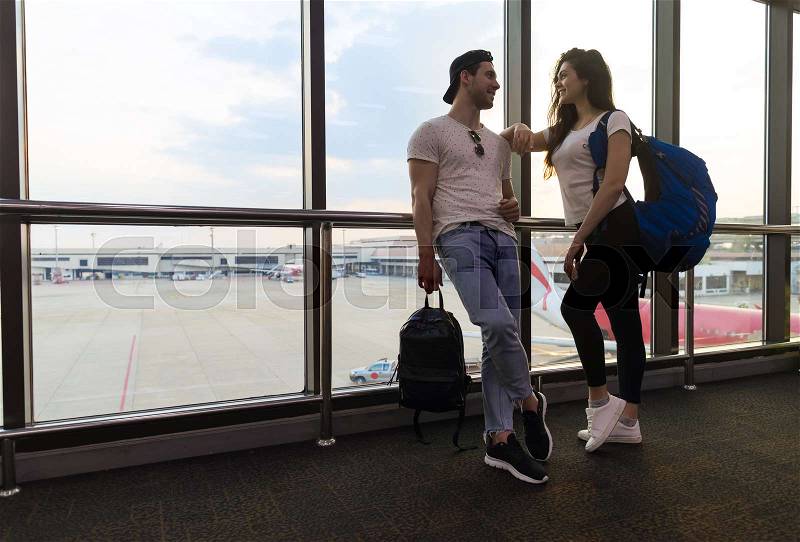 Young Couple In Airport Lounge Waiting Departure Happy Smile Man And Woman Flight Holiday Vacation Travel, stock photo