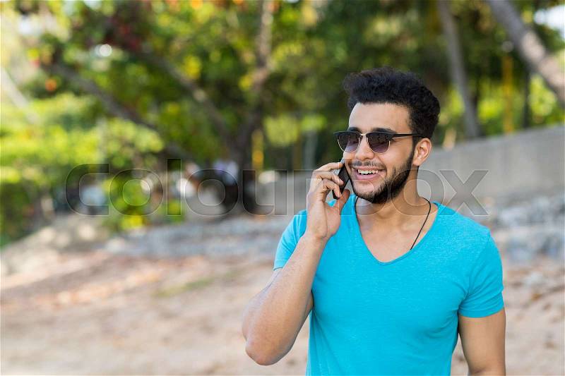 Young Hispanic Man Talking Phone Call Tropical Beach Sea Holiday Guy Summer Vacation Ocean Travel, stock photo