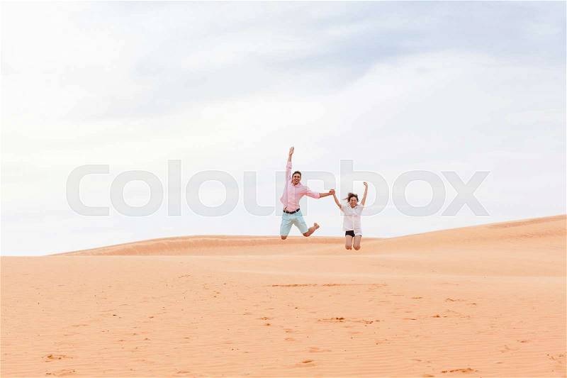 Young Man Woman Jump Up In Desert Beautiful Couple Asian Girl And Guy Sand Dune Landscape Background, stock photo