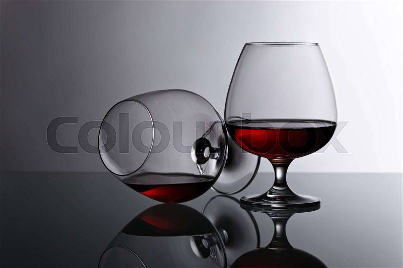 Two snifters of brandy on the reflective background, stock photo