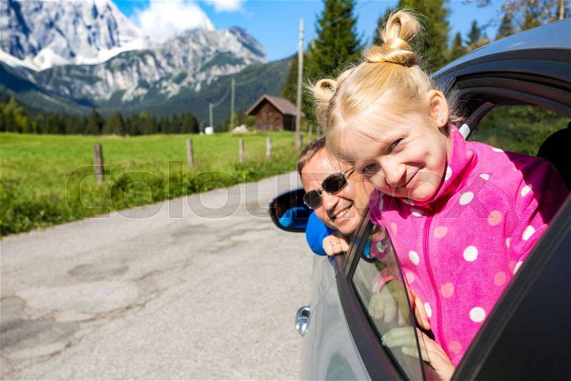 Happy dad and daughter looking out the car window and mountains in the background. Dolomites, Italy , stock photo