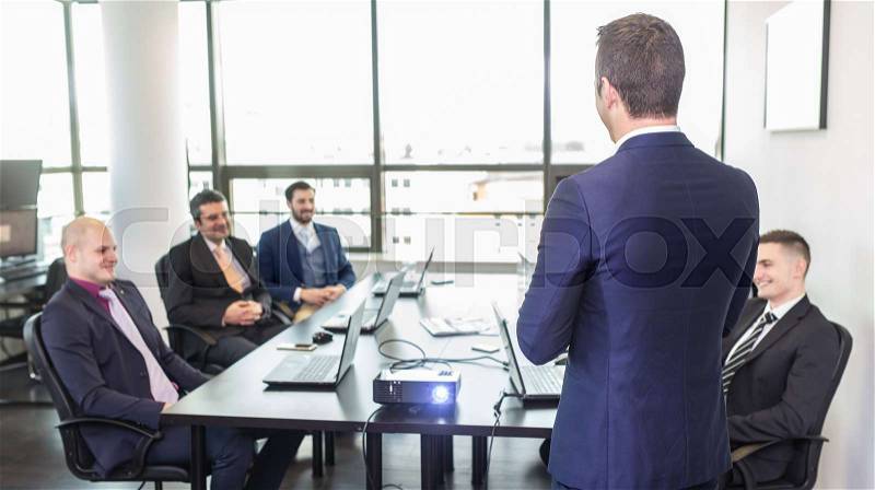 Successful team leader and business owner leading informal in-house business meeting. Business people with laptops in modern corporate office. Business and entrepreneurship concept, stock photo