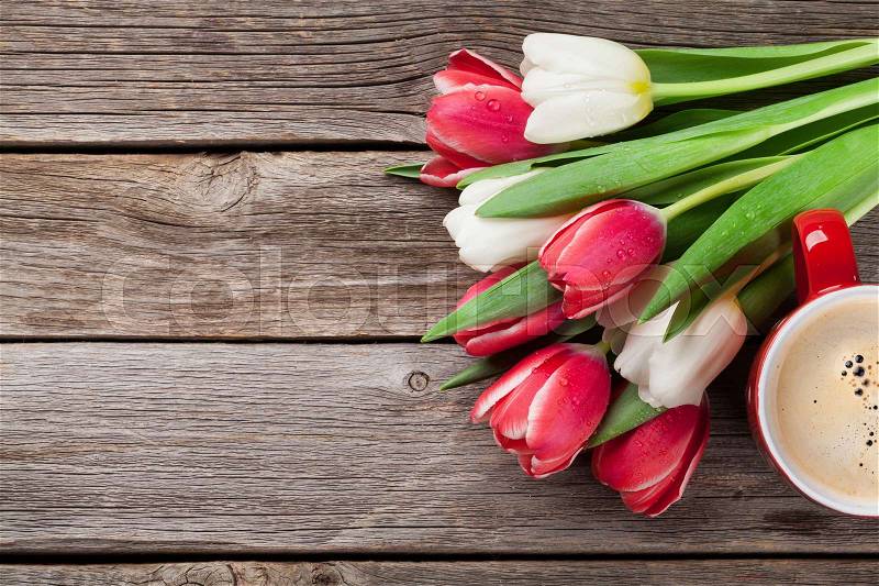 Colorful tulips bouquet and coffee cup on wooden background. Red and white. With space for your greetings, stock photo