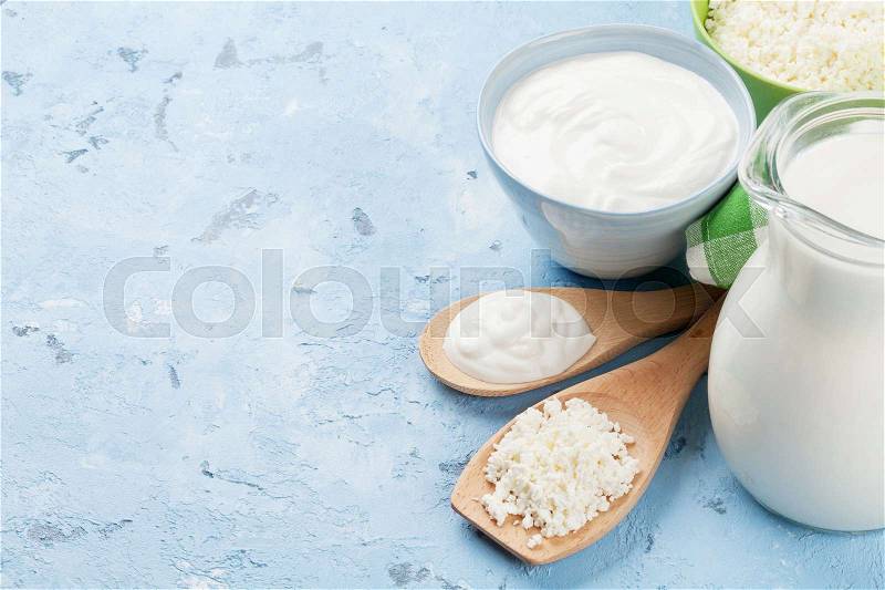 Dairy products on stone table. Sour cream, milk, cheese, yogurt and curd. View with copy space, stock photo