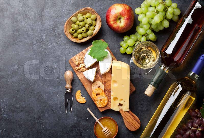 White wine, grape, bread and cheese on stone table. Top view with copy space, stock photo