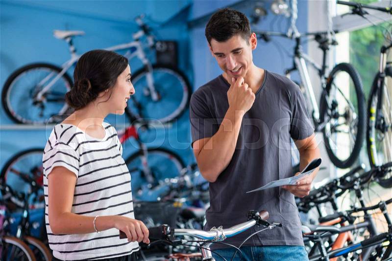 Couple looking for bicycle in bike shop, stock photo