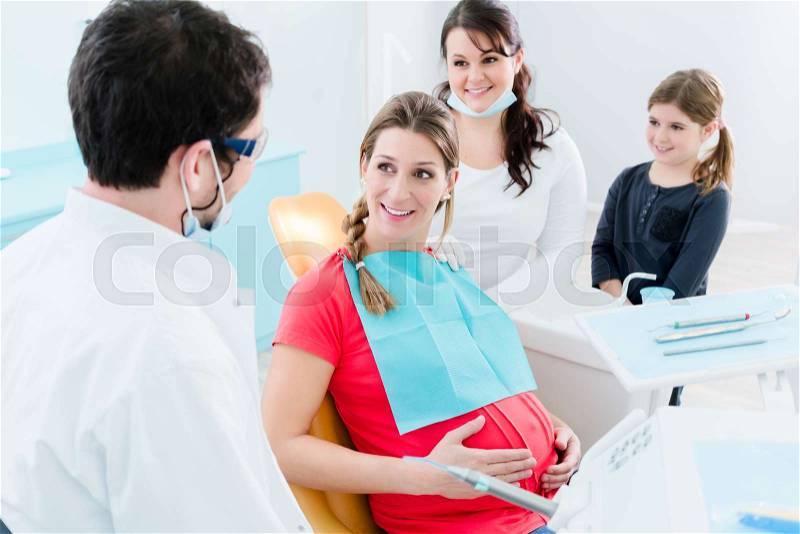 Pregnant woman at dentist before treatment, stock photo