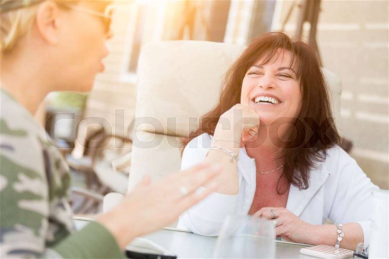 Two Female Friends Enjoying Conversation on the Patio, stock photo