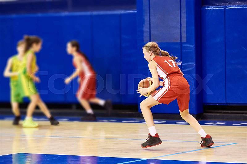 Girls athlete in sport uniform playing basketball indoors, stock photo