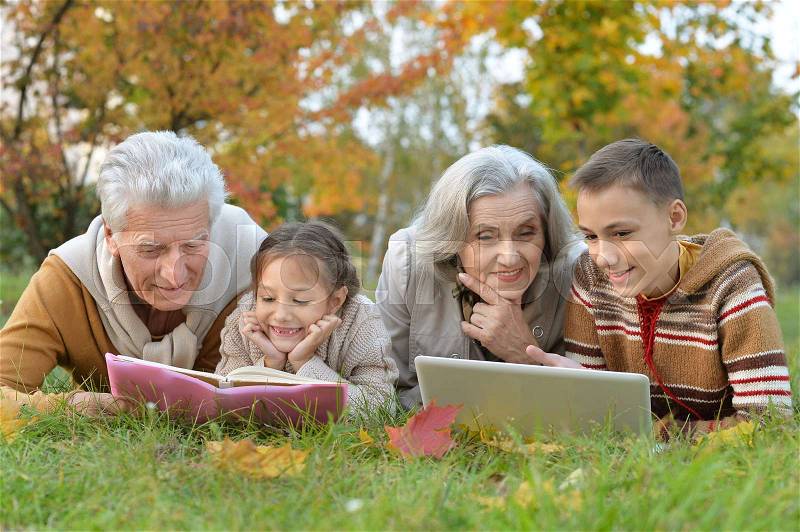 Grand parents spending time with grandchildren outdoors in autumn, stock photo