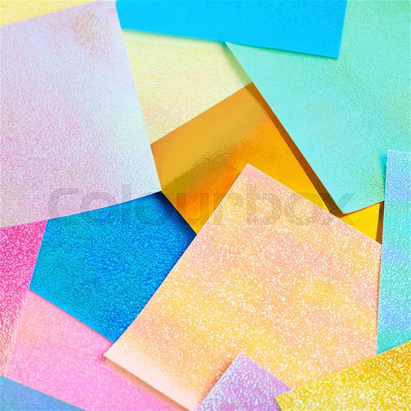 Surface coated with the multiple colorful origami paper sheets as an abstract background composition, stock photo