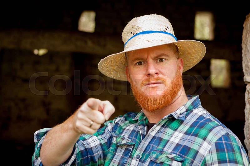 Red haired man with a straw hat in a rural enviroment, stock photo