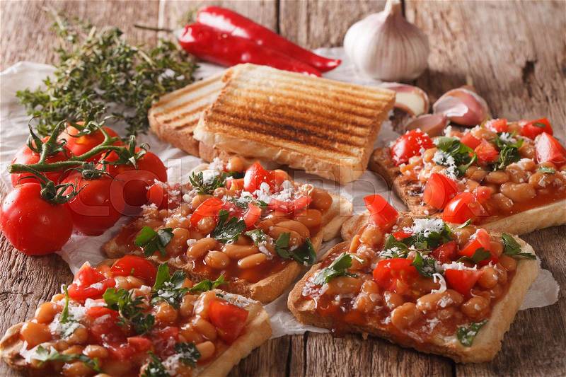 English breakfast: toast with white beans, tomatoes, cheese and garlic close-up on the table. horizontal , stock photo