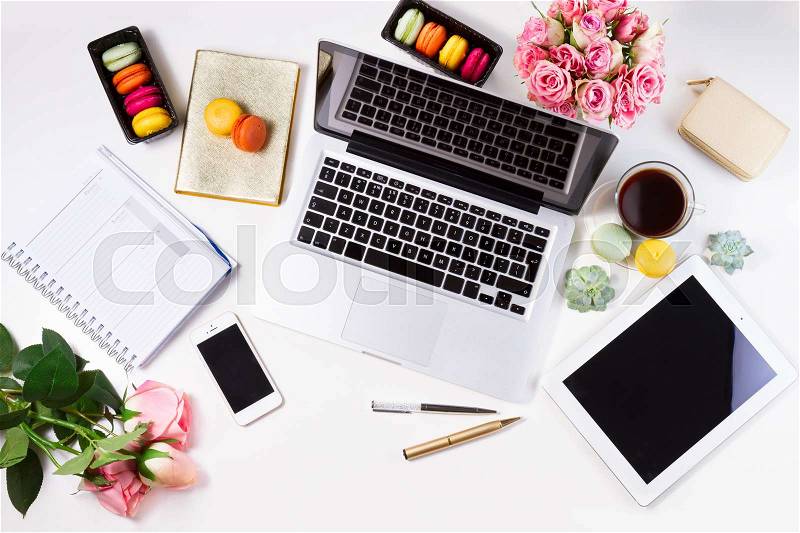 Feminine workspace with laptop, tablet and phone, top view, stock photo