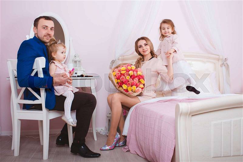 Young loving family of four people portrait in bedroom, stock photo
