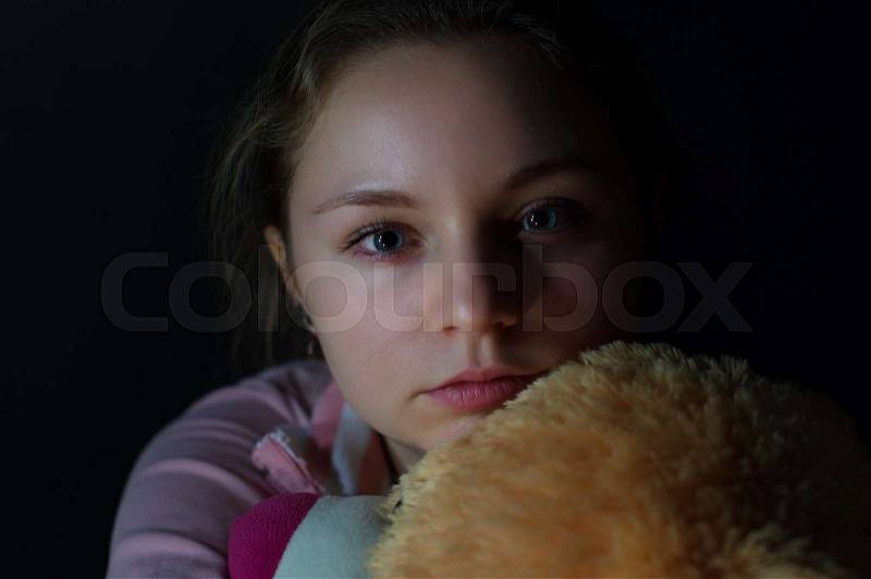Portrait of the sad girl on a dark background, stock photo