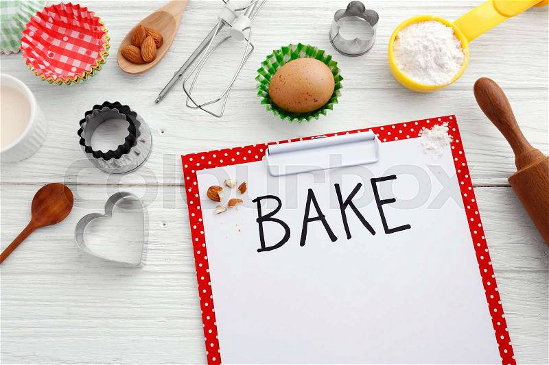 Baking background with baking ingredients and clipboard on wooden table, stock photo