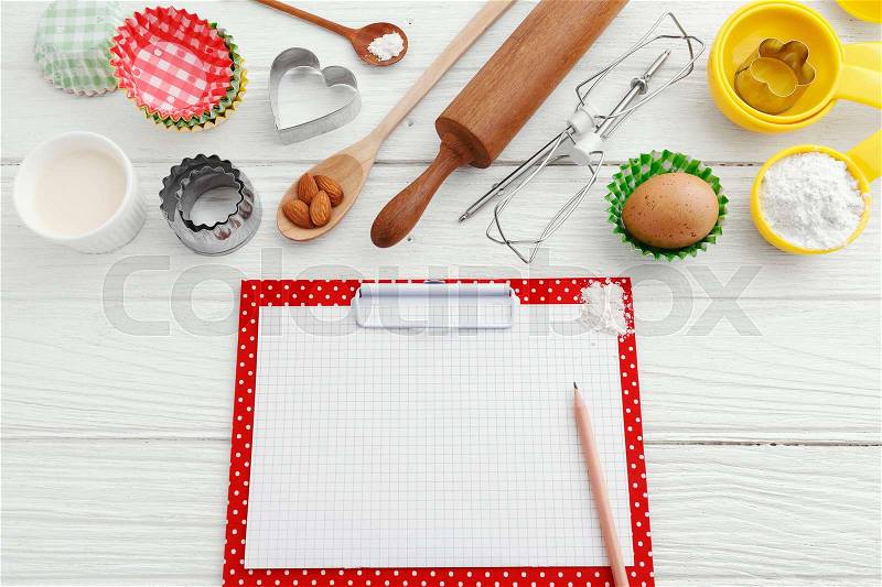 Baking background with clipboard and baking ingredients on white wooden table, stock photo