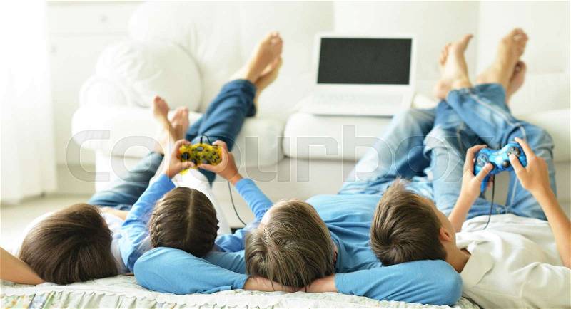 Kids with parents playing computer games at home, stock photo
