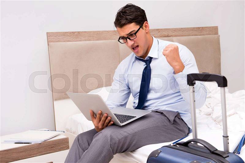 Businessman working during business trip in hotel, stock photo