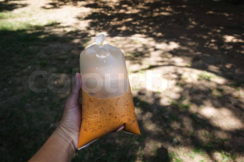 Bag of cool Thai coffee holding by hand in garden , Joyful with coffee time concept, stock photo
