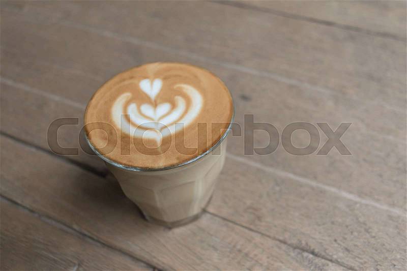 Hot glass of coffee on wooden table in the coffee shop, stock photo