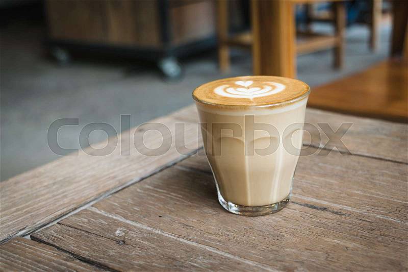 Hot glass of coffee on wooden table in the coffee shop, stock photo