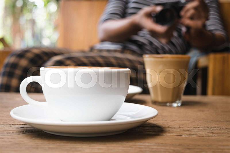 White cup of coffee on wooden table in the coffee shop, stock photo
