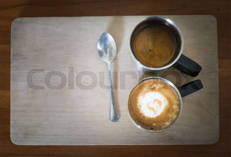 Hot dark coffee in stainless cup with cup of hot tea and stainless spoon on the wood. Dark coffee concept, stock photo