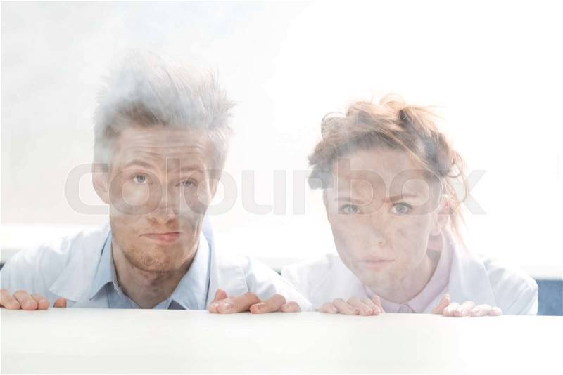 Portrait of scientists looking out behind table after experiment in lab on white, stock photo