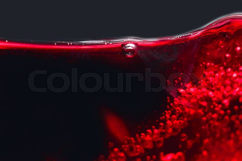 Abstract splashes of red wine on a black background, stock photo