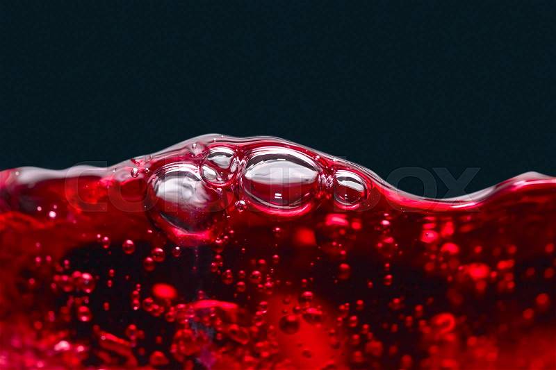 Abstract splashes of red wine on a black background, stock photo