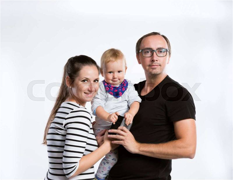 Beautiful young parents holding baby daughter in the arms. Studio shot on white background, stock photo