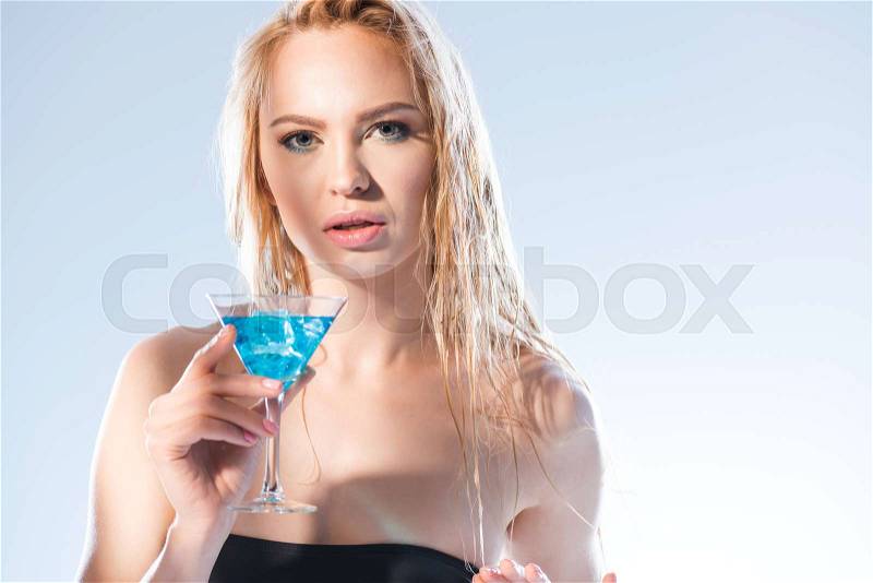Portrait of woman holding cocktail drink and looking to camera on white, stock photo