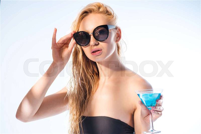 Portrait of woman with cocktail drink holding sunglasses on white, stock photo