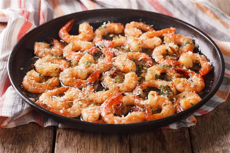 Flavorful food: shrimp in garlic sauce with parmesan cheese and herbs closeup on the table. horizontal , stock photo