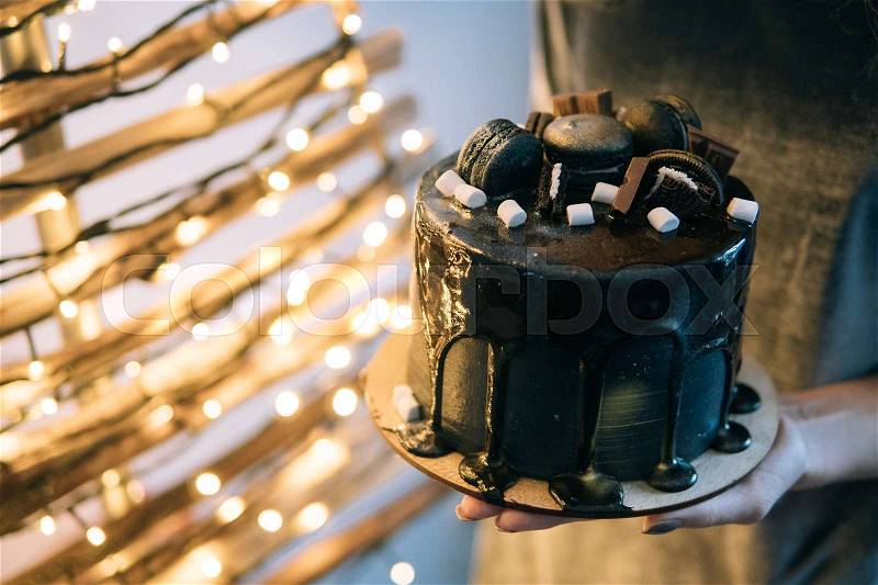 Beautiful designer chocolate cake someone holds on hands, stock photo