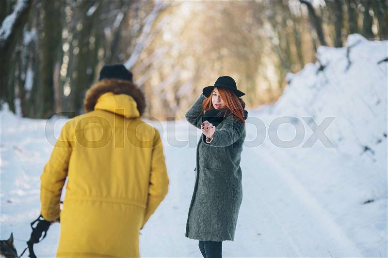 Couple with dog walking in the park in winter, stock photo