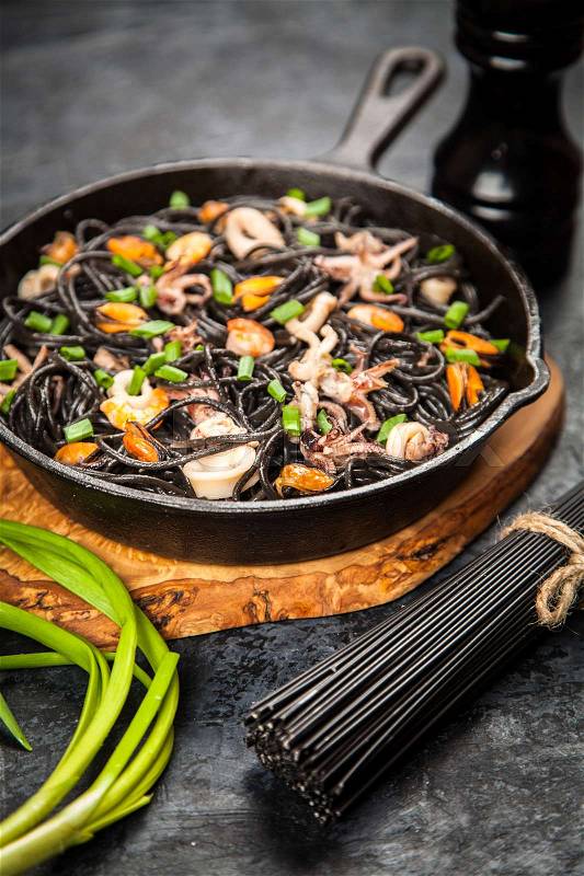 Black spaghetti made of squid ink with shrimps and other seafood, stock photo