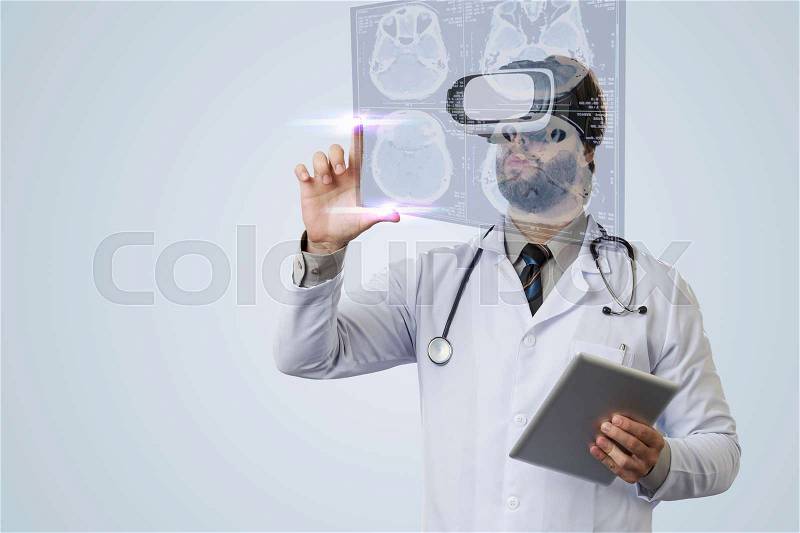 Male doctor on a gray background, using a Virtual Reality Glasses, looking at a virtual Screen, stock photo