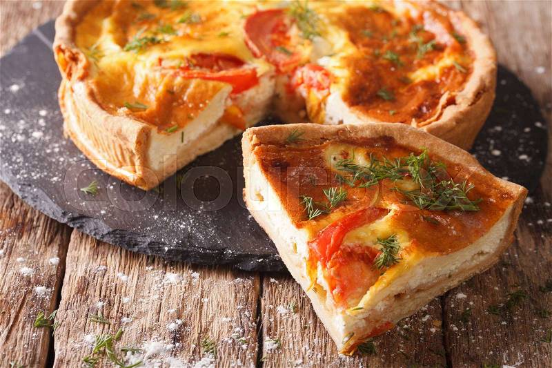 Delicious sliced pie with feta cheese, tomatoes and herbs closeup on the table. horizontal , stock photo