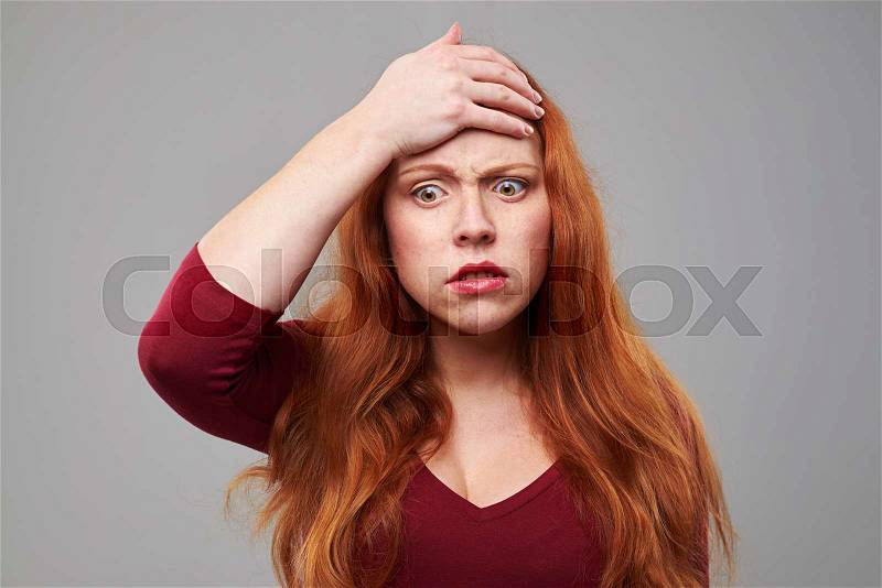 Close-up shot of anxious woman putting hand on forehead. Negative human emotion face expression, stock photo
