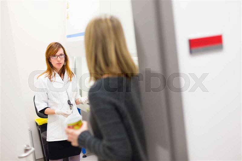 Young researcher and her supevisor discussing research project details in scientific laboratory, stock photo