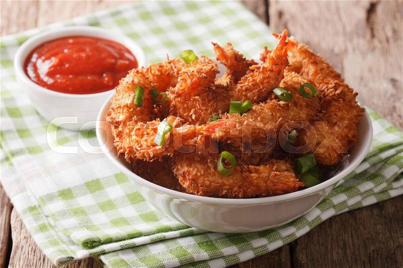 Fried shrimp in coconut breading and the sauce in a bowl close-up on the table. horizontal , stock photo