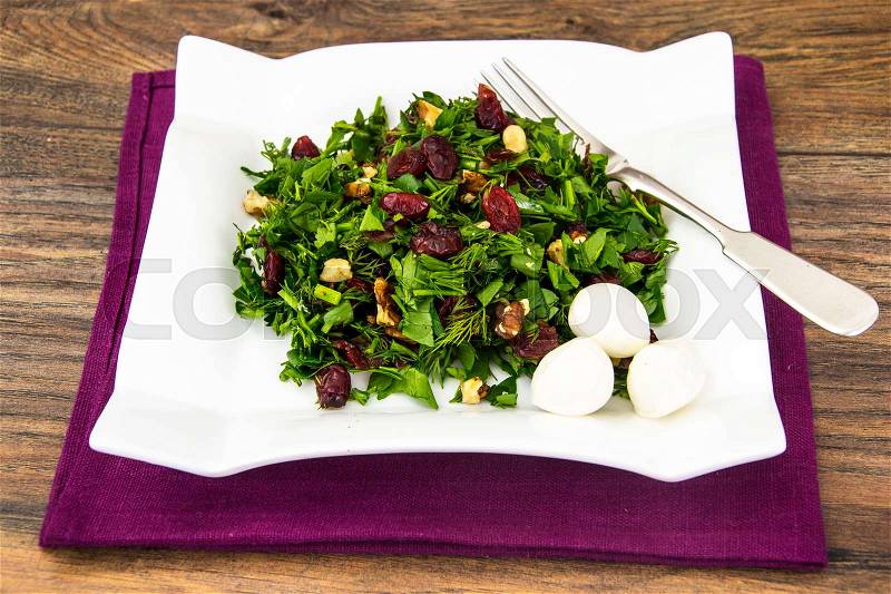 Salad of fresh greens with walnuts and sun-dried cherries. Studio Photo, stock photo