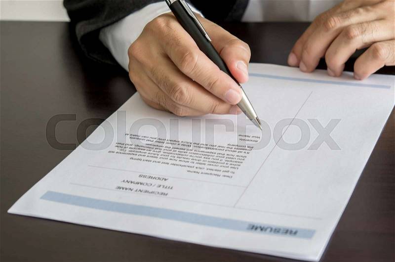 Close-up Businessman or job seeker signing on resume form, stock photo