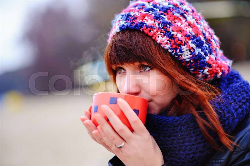 Woman drinking coffee by the sea, stock photo