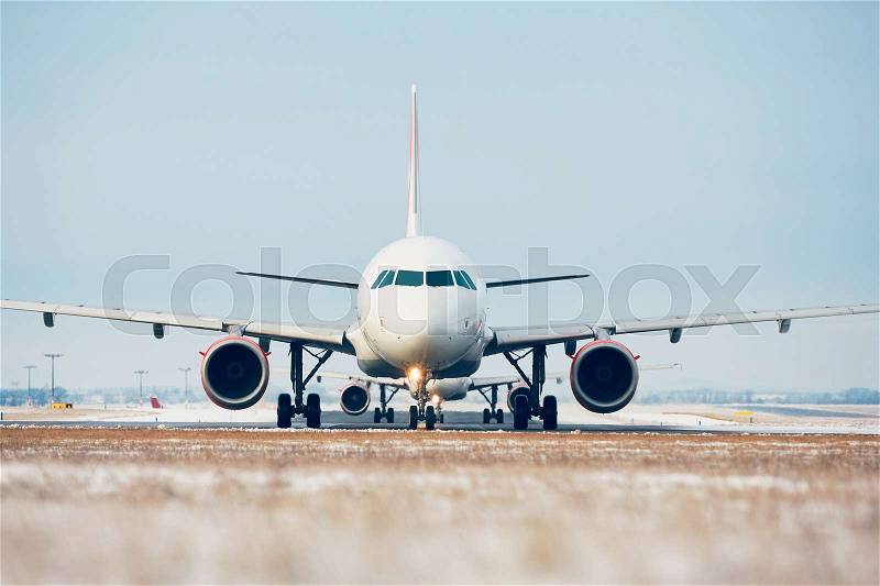 Airport in winter. Airplanes are taxiing to the runway for take off, stock photo