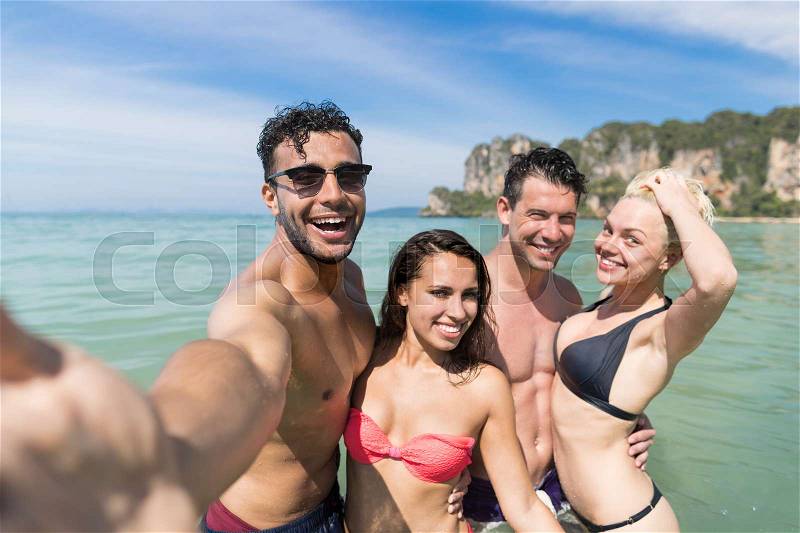 Young People Group On Beach Summer Vacation, Happy Smiling Friends Taking Selfie Photo In Water Sea Ocean Holiday Travel, stock photo
